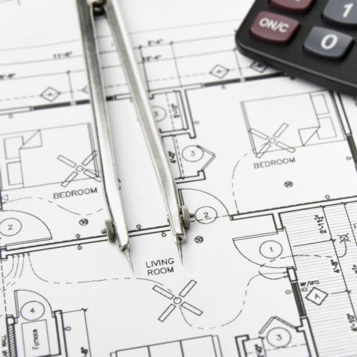Construction planning drawings on the table and two yellow pencils
